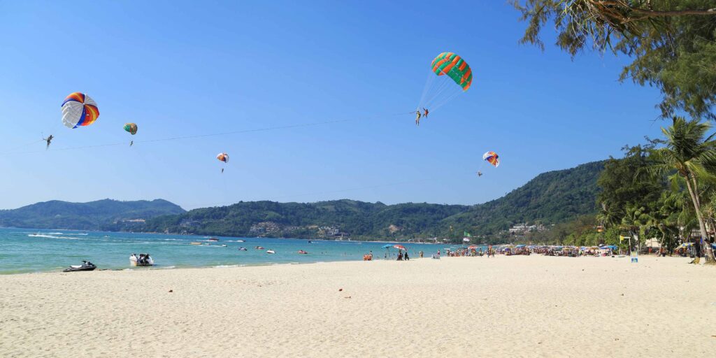 view of Patong Beach with parasailing in Phuket Thailand